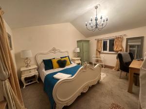 ein Schlafzimmer mit einem Bett und einem Kronleuchter in der Unterkunft Meagill Cottage Sleeps 4 with Hot Tub & Parking in Otley