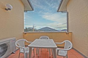 a white table and chairs on a balcony with a window at Colle di Rio - Goelba in Rio nellʼElba +3 photos