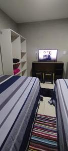 サン・ロレンソにあるDepartamento cama dobleのベッド2台とテレビ付きの机がある寝室
