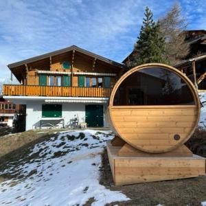 a large wooden mirror sitting in front of a house at Chalet La Lumiere by Alte Bock in Grächen