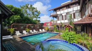 a swimming pool in front of a house at Greenheart Boutique Hotel in Paramaribo