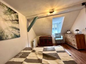 a bedroom with a bed and a dresser and a window at Altes Dichterhaus von 1859 in Miltenberg