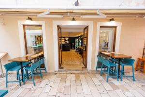 a restaurant with two tables and blue chairs at City Premium Heritage in Zadar