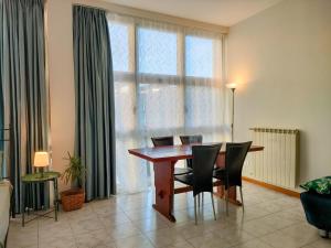 ein Esszimmer mit Tisch und Stühlen und einem Fenster in der Unterkunft Palestro Studio - A Cozy Apartment in Como in Como