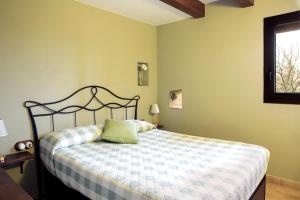 a bedroom with a bed with a checkered blanket at Allotjaments Plaça Major-Roure in Santa Pau