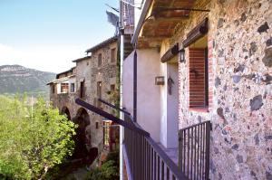 a building with a staircase leading up to a balcony at Allotjaments Plaça Major-Roure in Santa Pau