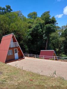 a barn with a red roof on top of a field at Sítio são longuinho in Extrema