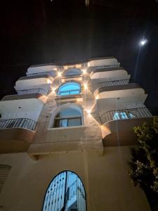 Un edificio con luces en el costado. en Al Ramla Guest House, en Luxor
