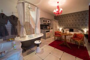 a bathroom with a tub and a sink and a table at Le Mascaret - Restaurant Hotel Spa - Teritoria in Blainville-sur-Mer