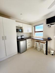 a kitchen with white cabinets and a table and chairs at The Tides in Simonʼs Town +28 photos
