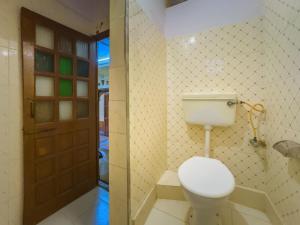 a bathroom with a toilet and a wooden door at Sagar Guest House in Jaisalmer +69 photos