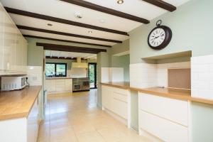 ChiddinglyにあるCountryside Retreat packed with Activities Tennis including Hot Tub, BBQ, Dartsの大きなキッチン(壁掛け時計付)