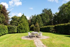 ChiddinglyにあるCountryside Retreat packed with Activities Tennis including Hot Tub, BBQ, Dartsの庭園に座るテーブルと椅子