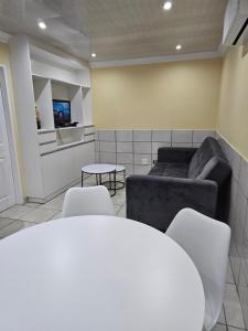 a living room with a couch and a table and chairs at LPM Guests R in Pretoria