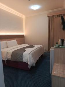 a hotel room with a bed and a television at فندق رفاق العالية in Makkah