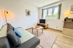 ein Wohnzimmer mit Couch und Tisch in der Unterkunft Joli appartement neuf Jardin 500 m des plages in Larmor-Plage