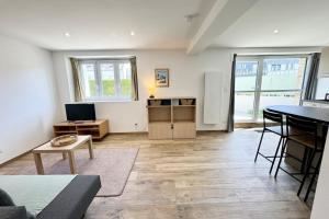ein Wohnzimmer mit einem Tisch und einem Kühlschrank in der Unterkunft Joli appartement neuf Jardin 500 m des plages in Larmor-Plage