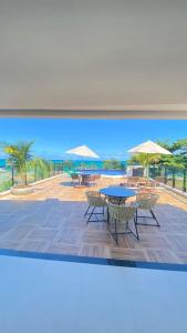 a painting of a patio with tables and umbrellas at Maraca Beach in Porto De Galinhas