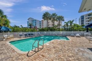 a swimming pool with chairs and umbrellas at Mariners Pointe 702 in Clearwater Beach