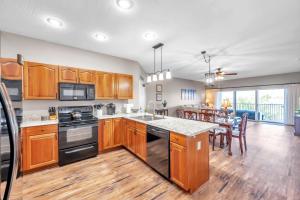 a kitchen with wooden cabinets and a dining room at Mariners Pointe 702 in Clearwater Beach