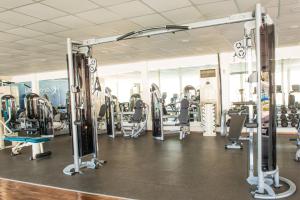 une salle de sport avec de nombreux tapis roulants et machines dans l'établissement C Hotel, à Manama