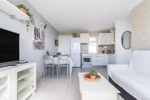 un soggiorno bianco con un divano bianco e una cucina di Corona Rosa Ocean View a Puerto Rico de Gran Canaria