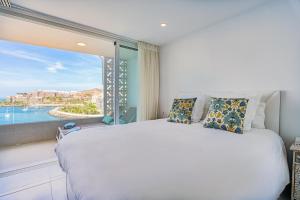 une chambre avec un grand lit et une grande fenêtre dans l'établissement Doñana Seaside Views by Homestaygrancanaria, à Patalavaca