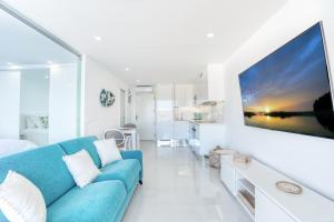 un salon avec un canapé bleu dans une pièce blanche dans l'établissement Doñana Seaside Views by Homestaygrancanaria, à Patalavaca