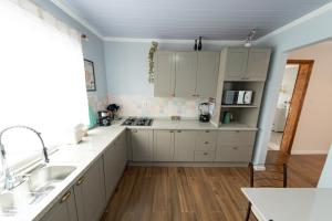 une cuisine avec des armoires blanches et un évier dans l'établissement Casa Luxuosa no Coração de Irati, à Irati