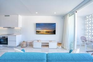 - un salon blanc avec un canapé bleu dans l'établissement Doñana Seaside Views by Homestaygrancanaria, à Patalavaca