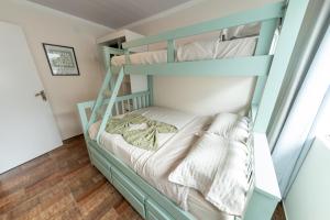 une chambre avec des lits superposés dans une pièce avec parquet dans l'établissement Casa Luxuosa no Coração de Irati, à Irati