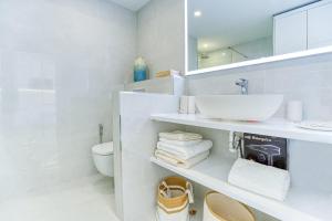 une salle de bain blanche avec un lavabo et des toilettes dans l'établissement Doñana Seaside Views by Homestaygrancanaria, à Patalavaca 29 autres photos