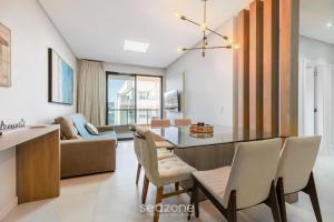 a dining room and living room with a table and chairs at DRL - Apartamentos a 300m da Praia de Bombinhas in Bombinhas