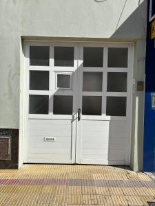 a white garage door on a building at Departamento Tandil in Tandil