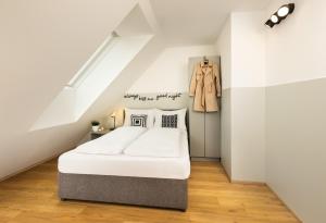 a bedroom with a bed and a coat on the wall at lyf Schönbrunn Vienna in Vienna +34 photos