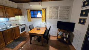 a small kitchen with a wooden table and a television at Hospetur 2 in Horta +7 photos