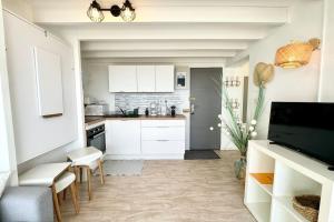 een keuken met witte kasten en witte werkbladen bij Superbe appartement duplex - Vue mer - Piscine in Guidel +13 foto's