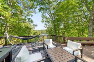 a deck with a hammock and tables and chairs at Lakeview Hideaway in Ellijay