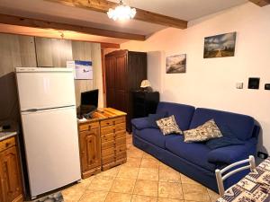 a living room with a blue couch and a refrigerator at Ca 'd Borla in Usseglio