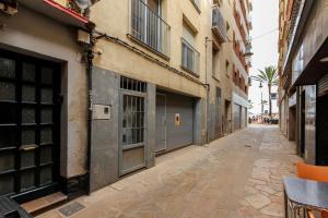 罗列特海岸Apartamento Jesma的建筑物之间的小巷里的一条空荡荡的街道