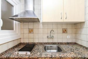 罗列特海岸Apartamento Jesma的厨房柜台设有水槽和炉灶。 更多13张照片