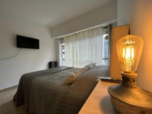 ein Schlafzimmer mit einem Bett und einer Lampe auf einem Tisch in der Unterkunft Alquiler de departamento en Mar del Plata in Mar del Plata + 36 Fotos