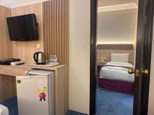 a small room with a bed and a refrigerator at فندق رفاق العالية in Makkah
