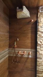 a shower with a light on a wooden wall at Casa Antón O Cebreiro in O Cebreiro
