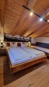 een groot bed in een kamer met houten plafonds bij Appartement Wälderhof in Kaprun