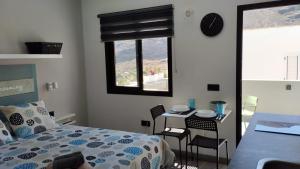 a bedroom with a bed and a table with chairs at Loft Mouly in San Sebastián de la Gomera