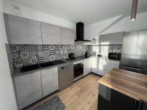 a kitchen with stainless steel appliances and a wooden table at Maison au calme in Villersexel
