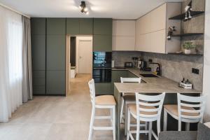 a kitchen with green cabinets and a counter with stools at Apartment Aria 3 in Velingrad