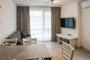 una sala de estar con una mesa y un sofá en Apartment Aria 3, en Velingrad