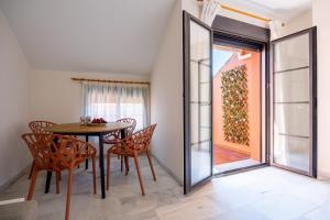 una sala da pranzo con tavolo, sedie e una finestra di Atico Gran Esperanza a Fuengirola